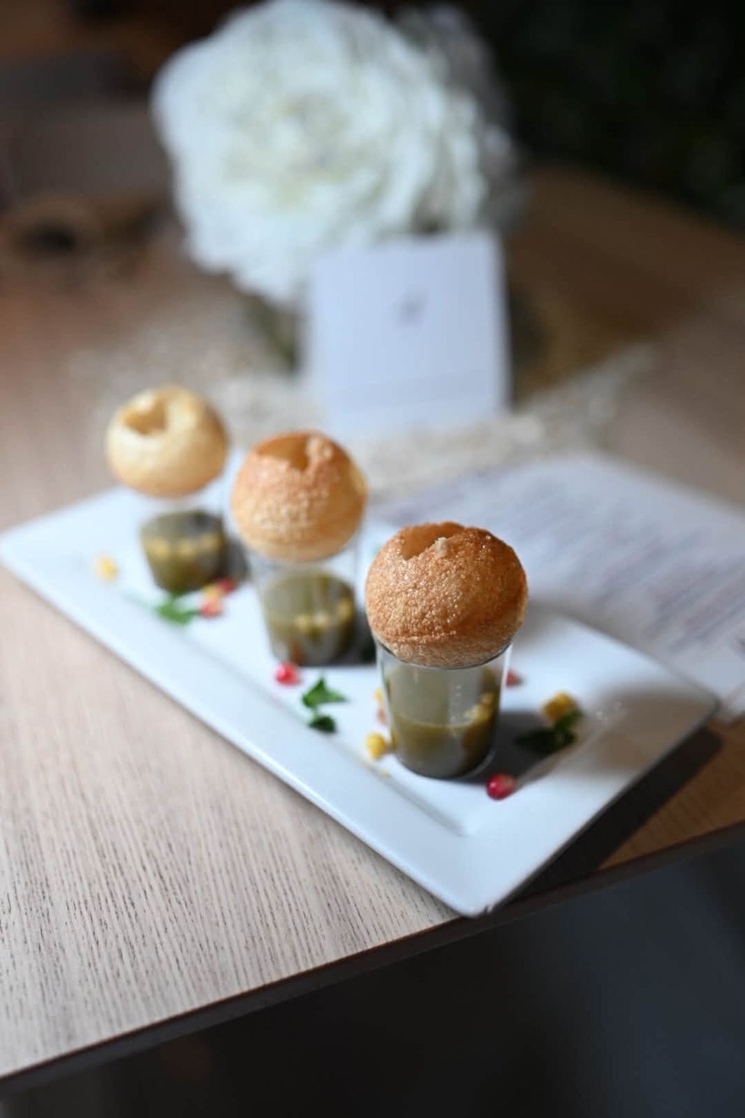 Pani puri shots served on a white plate