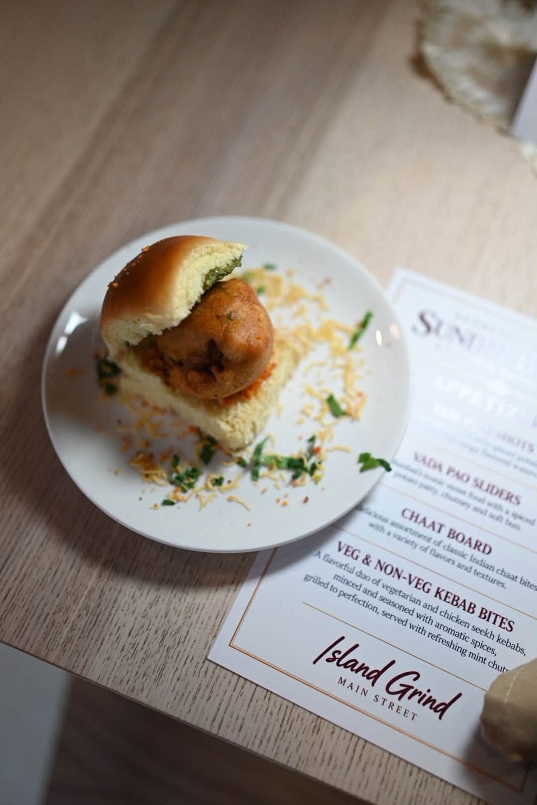 Vada pao slider beside the Island Grind brunch menu